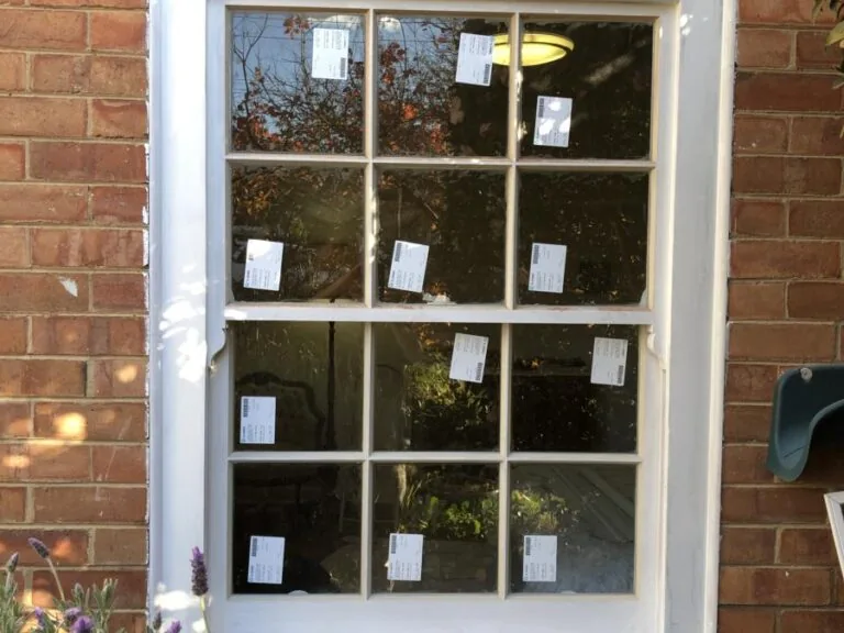 New timber sash window in a brick wall, with the glazing labels still on the glass
