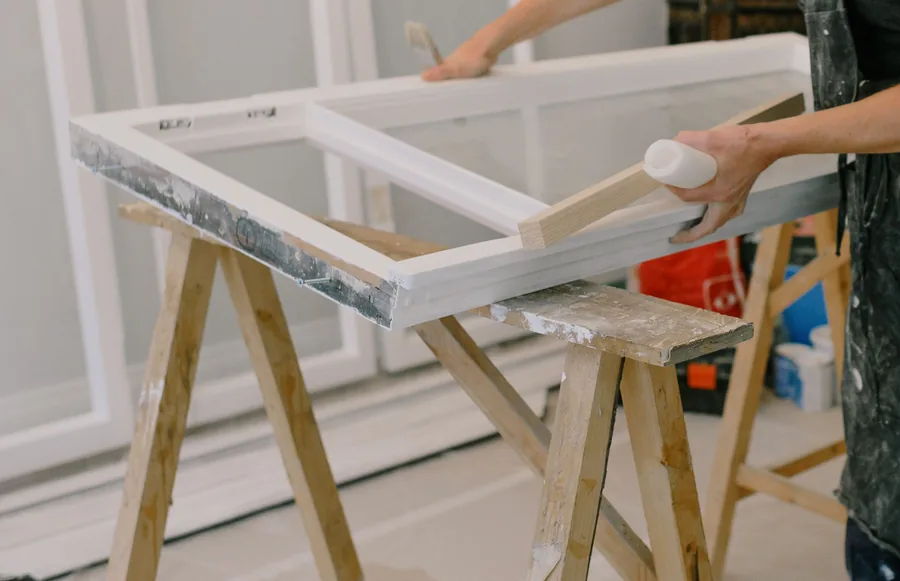 A painted timber sash being restored on trestles